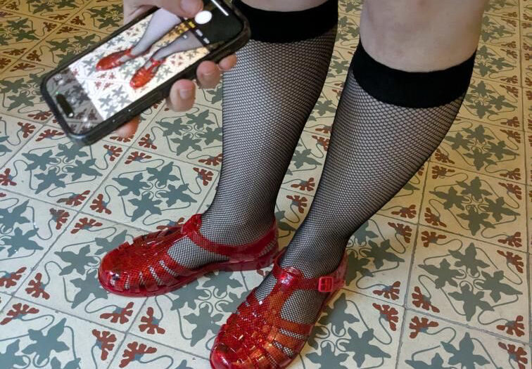 Foto einer Person, die ein Foto ihrer Schuhe macht - sie steht auf einem Fliesenboden